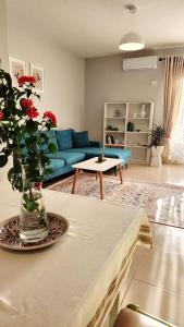 sala de estar con sofá azul y mesa en Divjaka Apartments 2 - City Center, en Divjakë