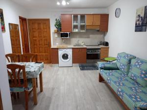 cocina y sala de estar con mesa y sofá en alojamientosmomi3, en Corralejo