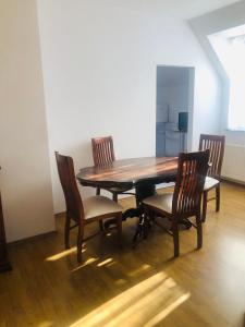 Podkowa Leśna的住宿－Apartament Plumeria w Podkowie Leśnej，餐桌、椅子和木桌