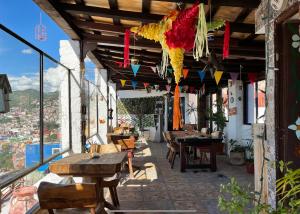 un patio con mesas de madera, sillas y banderas en HOTEL CASONA DE LAS AVES, en Guanajuato