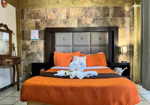 ein Schlafzimmer mit einem orangenen Bett mit Handtüchern darauf in der Unterkunft HOTEL CASONA DE LAS AVES in Guanajuato
