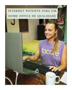una mujer sentada en un escritorio con un ordenador portátil en Buddy's Hostel Itacaré, en Itacaré