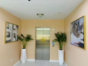 a hallway with two potted plants and a elevator at The New View Inn in Tortola Island