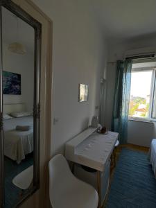 a bathroom with a mirror and a sink and a bed at Guest House Enny in Dubrovnik