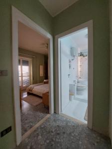 uma porta aberta para um quarto com uma cama e uma casa de banho em Appartamento CasaZeta luminoso e centralissimo em Latina