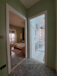 an open door to a bedroom with a bed and a bathroom at Appartamento CasaZeta luminoso e centralissimo in Latina +43 photos