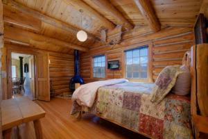 um quarto com uma cama num chalé de madeira em JHRL - Macker's Cabin, Amazing Log Cabin, Sleeps 16 em Wilson