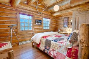 um quarto com uma cama num chalé de madeira em JHRL - Macker's Cabin, Amazing Log Cabin, Sleeps 16 em Wilson