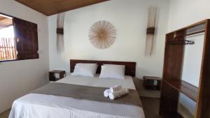 a bedroom with a bed with two towels on it at Reserva Rede e Mar - Rota dos Milagres - Patacho in Pôrto de Pedras