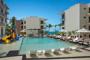 a swimming pool with chairs and a slide at a hotel at Dreams Cozumel Cape Resort & Spa in Cozumel