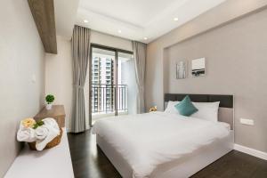 - une chambre avec un grand lit blanc et une fenêtre dans l'établissement Spacious Saigon, à Hô-Chi-Minh-Ville