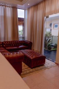a living room with a leather couch and a ottoman at HAUER HOTEL in San Vicente
