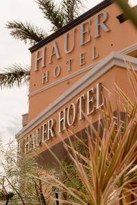a building with a sign for a larger hotel at HAUER HOTEL in San Vicente