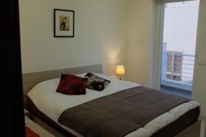 ein Schlafzimmer mit einem Bett mit zwei Kissen darauf in der Unterkunft Sunset and Seaview Apartment -Brand New in Mellieħa