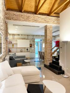 a living room with white furniture and a brick wall at Blue Domino Luxury City Villa Patras in Patra