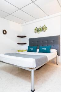 uma cama grande com almofadas azuis num quarto em Hotel Ayenda Guadalupe em Neiva