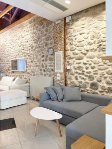 a living room with a couch and a stone wall at Blue Domino Luxury City Villa Patras in Patra