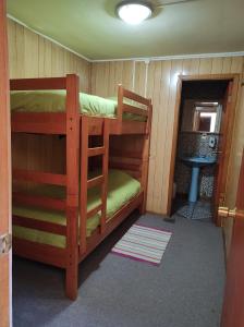 a room with two bunk beds in a cabin at La Minga Hostel in Castro