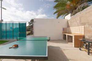 una mesa de ping pong con una pelota de ping pong. en clemente house,private pool, en Arafo