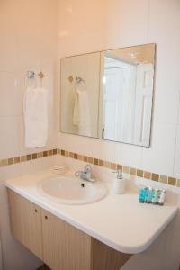 a bathroom with a sink and a mirror at Morne SeaView Apartments in Castries
