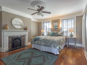 ein Schlafzimmer mit einem Bett und einem Kamin in der Unterkunft Southern Belle Skyline in Savannah