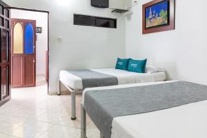 a room with two beds and a door at Hotel Ayenda Guadalupe in Neiva