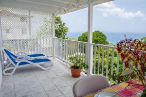 a white porch with a chair and a table at Morne SeaView Apartments in Castries