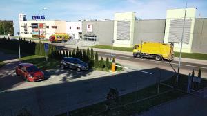 two cars and a yellow truck on a street at Apartament Elegant 1 in Przemyśl +2 photos