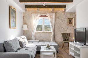 ein Wohnzimmer mit Sofa und Fernseher in der Unterkunft Villa Sinodium in Umljanović
