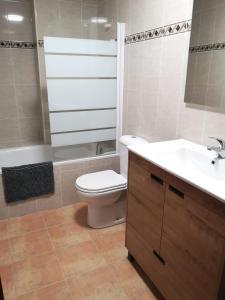 La salle de bains est pourvue de toilettes blanches et d'un lavabo. dans l'établissement Apartamento Las Huellas, à Arnedillo