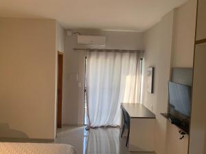 une chambre avec un lit, une télévision et une fenêtre dans l'établissement TODDES EXCLUSIVE RESORT, à Paragominas