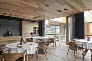un restaurant avec des tables blanches, des chaises et des fenêtres dans l'établissement Guest House Hiša Denk, à Zgornja Kungota