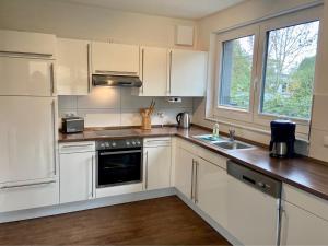 a kitchen with white cabinets and a sink and a window at 1370- Annina 2 in Dahme