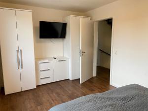 a bedroom with white cabinets and a flat screen tv at 1380- Annina 3 in Dahme