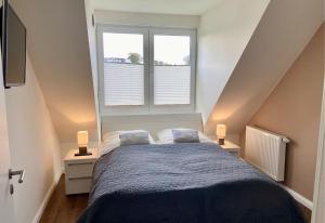Un dormitorio con una cama y dos ventanas. en 1380- Annina 3, en Dahme