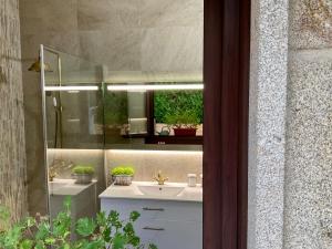 y baño con lavabo y espejo. en Casa Nueva de Vigo con Jacuzzi y chimenea en Mos