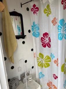baño con cortina de ducha con flores en Cabaña Rústica Villa Alicia, en Paipa