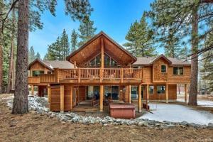 una cabaña de madera en el bosque con una cubierta envolvente en Skier's Dream! Mansion Right Next to Heavenly en South Lake Tahoe