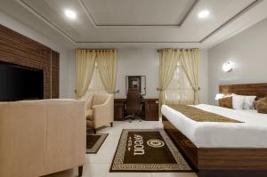 Aveon Hotel في أبوجا: غرفة فندقية بسريرين ومكتب وتلفزيون