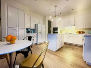 a kitchen with white cabinets and a table with oranges on it at King Bed Quiet Home on Cul-de-Sac Hiking Trails in Roseville