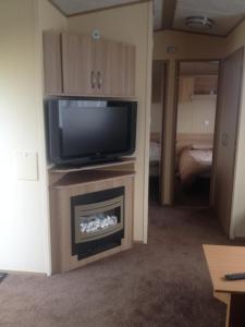 a living room with a tv and a fireplace at The Pad at Lido Beach in Prestatyn