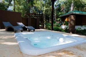 a jacuzzi tub with two chairs in a yard at Village Cataratas in Puerto Iguazú