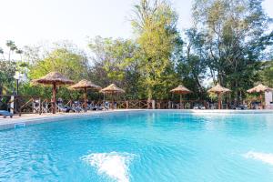 uma grande piscina com guarda-sóis e cadeiras em Village Cataratas em Porto Iguaçu