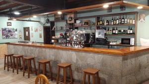 a bar with stools in a room with a counter at Hostal Rio Duero in Molinos de Duero