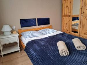 sypialnia z dużym łóżkiem i ręcznikami na nim w obiekcie Apartamenty i Pokoje Piaskowy Mak w Łebie