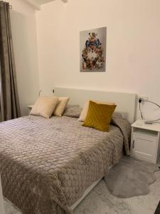 ein Schlafzimmer mit einem Bett und einem Bild an der Wand in der Unterkunft Villetta Gramsci, Alassio in Alassio