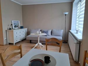 salon z kanapą i stołem w obiekcie Apartamenty i Pokoje Piaskowy Mak w Łebie