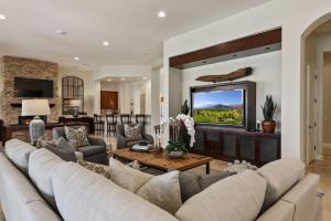 a living room with a large couch and a television at Escape to Legends - Pool, Games & Amazing Mountain Views in PGA West #067651 5br in La Quinta