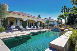 a swimming pool with chairs and a house at Escape to Legends - Pool, Games & Amazing Mountain Views in PGA West #067651 5br in La Quinta