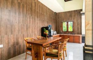 uma sala de jantar com uma mesa de madeira e cadeiras em Rendira villa 2 em Ubud